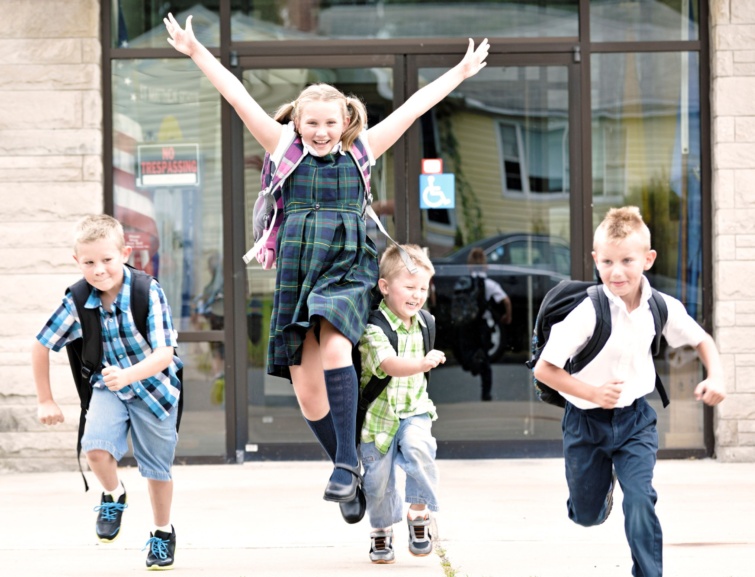 Diákok örülnek az iskola épülete előtt.